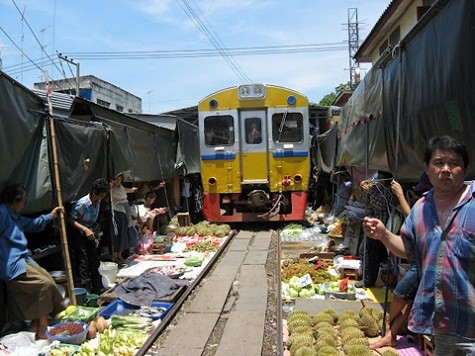 Mặc dù con tàu đi qua nhưng hoa quả vẫn mặc nhiên được bày bán bên mép đường sắt. Hình ảnh một chuyến tàu đi xuyên qua chợ.