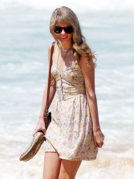 Nữ ca sĩ xinh đẹp Taylor Swift váy hoa, tay cầm đôi giày thoải mái trên bãi biển Sydney, Úc. Đây là giây phút thư giãn hiếm có của người đẹp trong khi cô vẫn đang có tour diễn "Speak Now" tại đây.