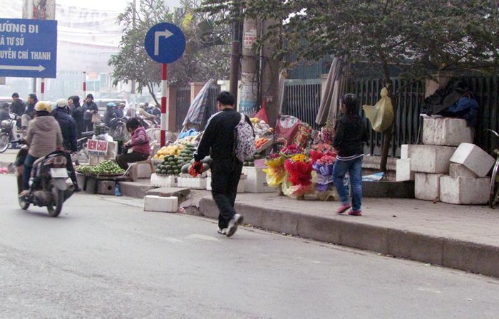 Những điểm bán quả không chỉ chiếm toàn bộ vỉa hè bán hàng, để đồ, mà họ còn kê thêm cả những tấm bê tông ở dưới lòng đường để có chỗ kê hàng.