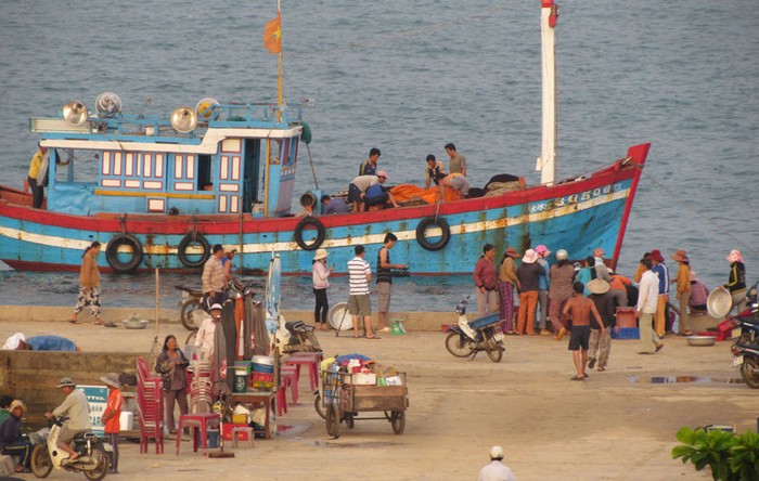 Mới hơn 5 giờ sáng, trên cầu cảng của đảo Lý Sơn đã tấp nập người chờ thuyền cá trở về.