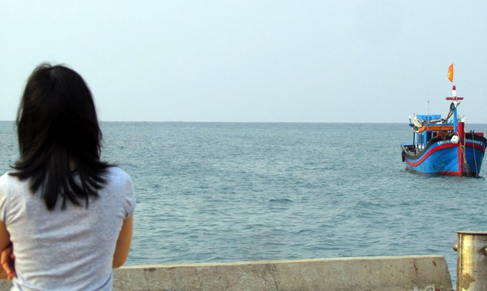 Một người phụ nữ trẻ nhìn ra biển ngóng tin của người thân trở về.