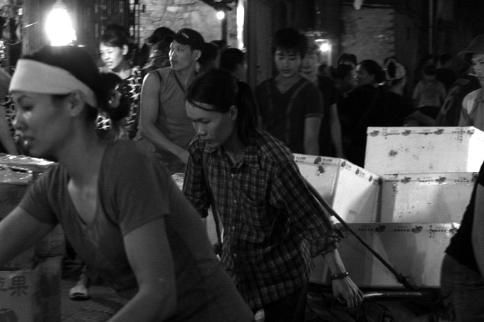 Nhiều chị cửu vạn làm việc quần quật cả đêm tại chợ đầu mối rau quả bến xe Long Biên, đến sáng lại chạy sang chợ Đồng Xuân để làm cửu vạn tiếp tục.