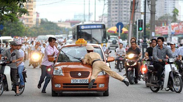 Cảnh sát giao thông bị hất lên nắp capo không phải chuyện hiếm ở Hà Nội
