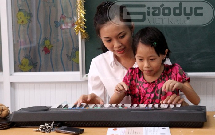 Hồ Thị Phương Thảo chơi đàn cùng một bé gái