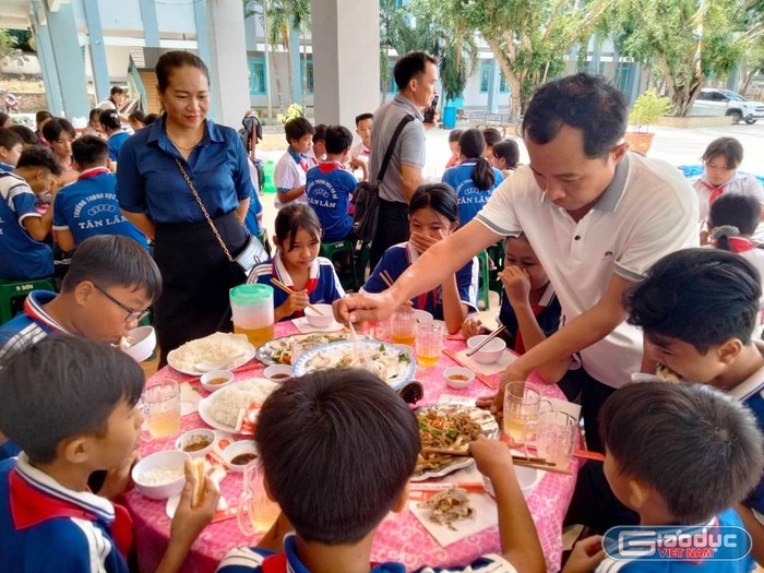 Thầy giáo Hoan chăm sóc cho học sinh trong “Bữa ăn tình thầy trò&quot;.