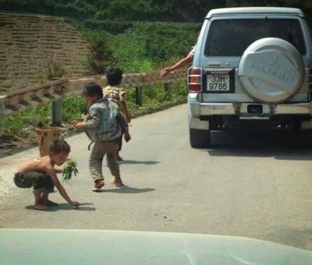 Những đứa trẻ dọc đường đi lên cao nguyên đá Đồng Văn hồn nhiên chạy ra nhặt kẹo do những người ngồi trên xe Pajero vứt ra - ảnh: nguoiduatin.vn