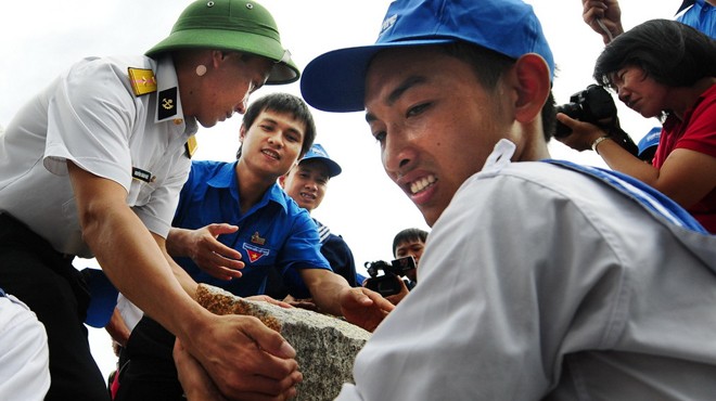 Các đoàn viên, thanh niên và chiến sĩ hải quân chuyển đá lên tàu ra đảo Đá Tây, huyện đảo Trường Sa, tỉnh Khánh Hòa (ảnh: Tuổi trẻ).