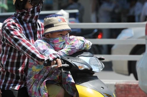 Trẻ em ra đường cần được mặc áo chống nắng đầy đủ. Ảnh: VnExpress