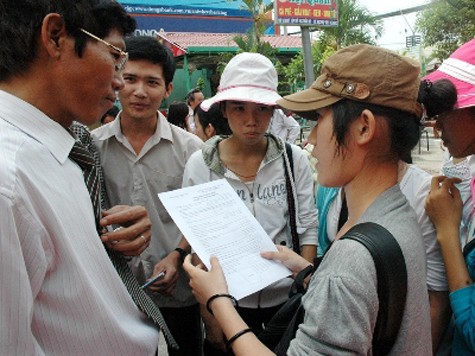 Ông Nguyễn Quốc Cường hướng dẫn học viên Trung tâm BDVH - luyện thi ĐH 60 An Sương cách làm hồ sơ ĐKDT Ảnh: Quang Phương.