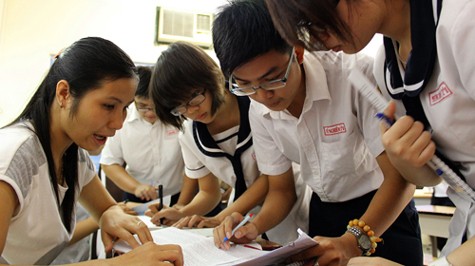 Thời điểm này, các trường THPT đã triển khai các thông tin tuyển sinh đến học sinh. Trong ảnh: cô Nguyễn Thị Chiên, cán bộ phòng học vụ Trường THPT Hùng Vương, Q.5, TP.HCM, hướng dẫn học sinh cách ghi hồ sơ đăng ký dự thi sáng 21-3-2012 - Ảnh: Như Hùng