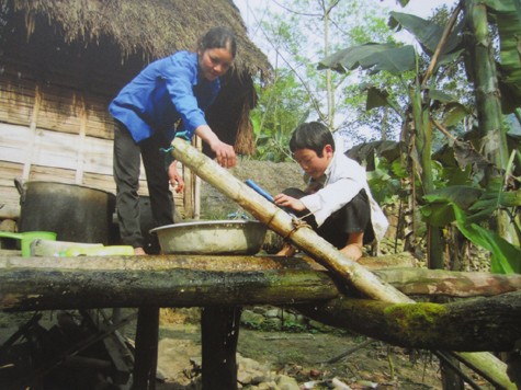 Cùng mẹ lấy nước lên nhà bằng hệ thống dẫn nước bằng ống gỗ tự tạo.