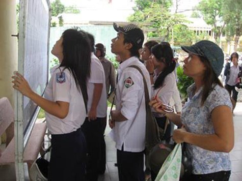 Học sinh và phụ huynh tìm hiểu thông tin thi vào lớp 10 năm 2011. (Ảnh VietNamNet)