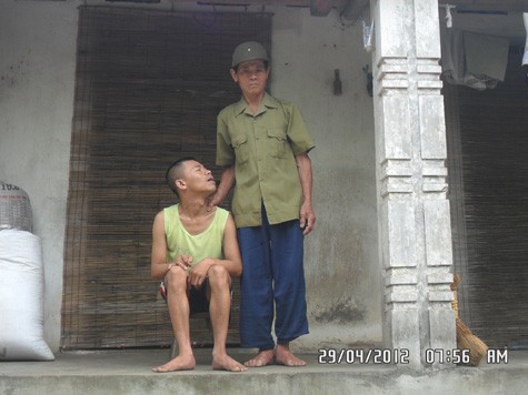 Ông Phạm Dư Uông bên người con trai ngây dại của mình.
