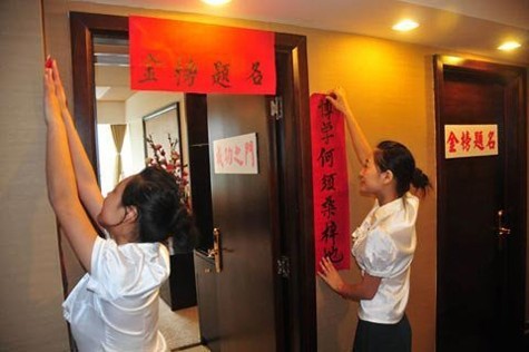 Nhân viên của một khách sạn ở Nanchong, tỉnh Tứ Xuyên đang dán cặp câu đối chúc các thí sinh thành công trong kì thi đại học đang cận kề.