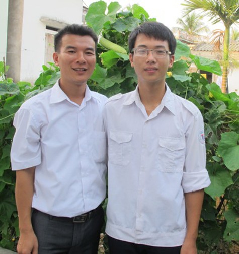 Em Vũ Văn Thanh (bên phải) cùng thầy giáo chủ nhiệm Nguyễn Văn Toàn.