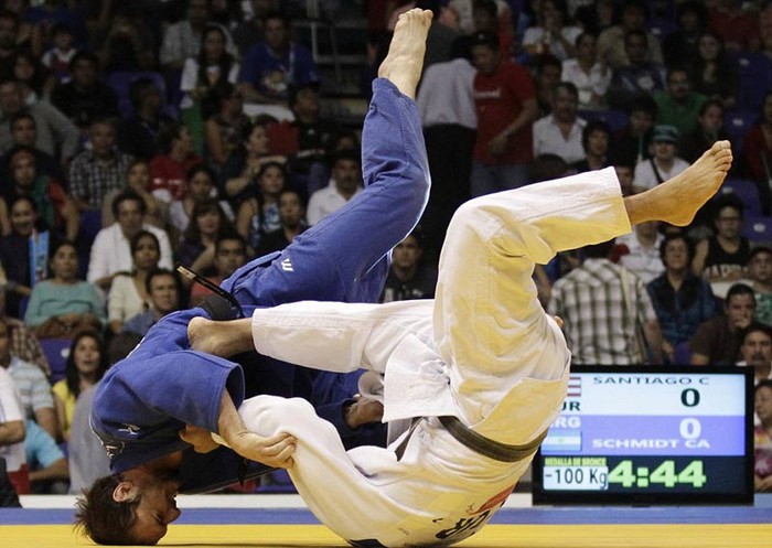 Cristian Adolfo Schmidt của Argentina (áo xanh) cố sức vật ngã Carlos Santiago của Puerto Rico trong trận tranh huy chương Đồng nội dung 100kg môn Judo ở Đại hội thể thao Trung Mỹ diễn ra tại Guadalajara, Mexico
