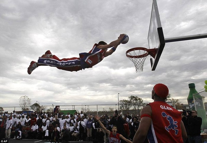 Một nam sinh trường trung học bay người thực hiện cú slam dunk trong trận đấu ở giải bóng rổ trung học