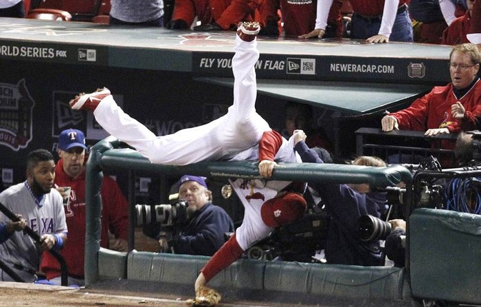 David Freese của đội St Louis Cardinal bay người qua hàng rào để cứu bóng trong trận bóng chày với Texas Rangers