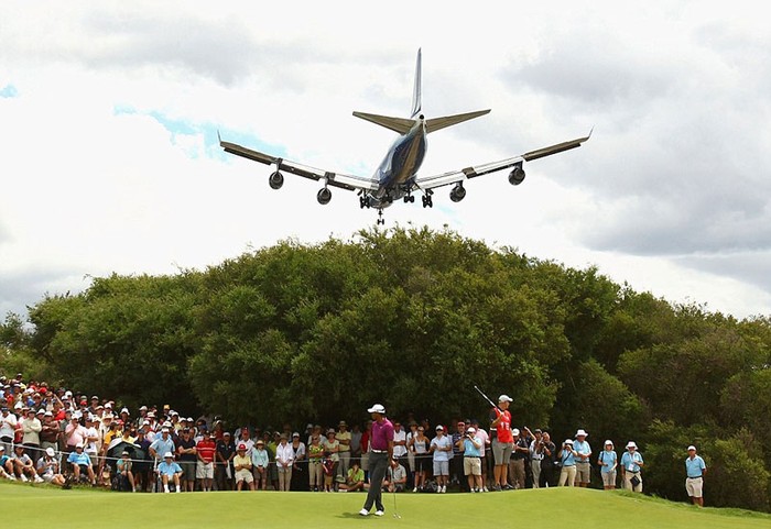 Một chiếc Boeing 747 bay ngang qua một sân golf tại Sydney trong lúc Tiger Woods thực hiện cú đánh ở lỗ thứ 7