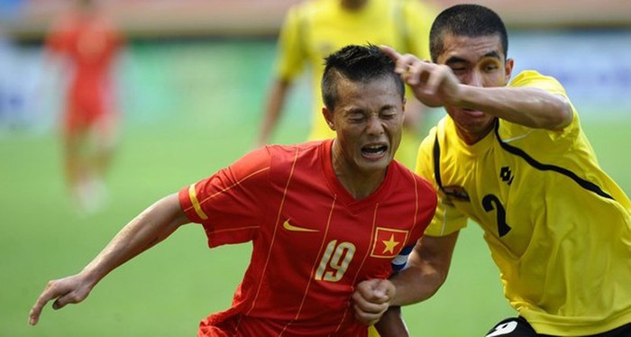 Phạm Thành Lương (trái) tranh bóng với Mohamamad Azri B Zahari (Brunei) trong trận đấu diễn ra ở bảng B bộ môn bóng đá Nam.