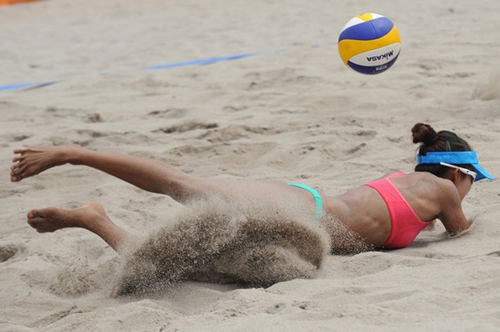 Một cầu thủ bóng chuyền bãi biển nữ Indonesia mất thăng bằng trong trận đấu với Malaysia.