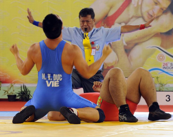 Nguyễn Văn Dực (trái) ăn mừng sau khi đánh bại Chivinn Chum (Cambodia), ở hạng cân 120kg môn vật tự do.
