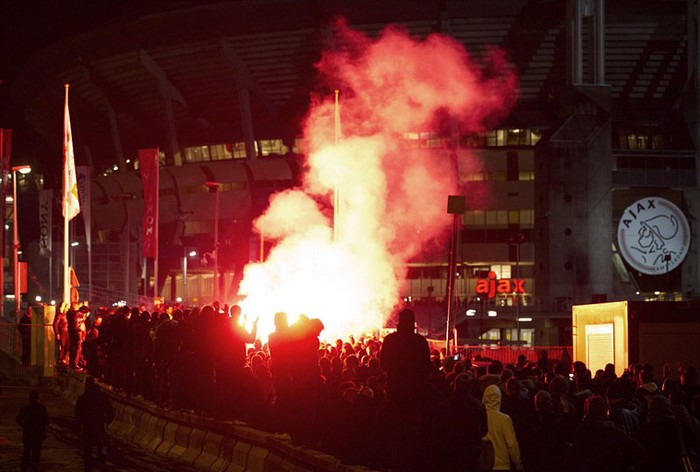 Fan của Ajax tụ tập và đốt pháo bên ngoài SVĐ Amsterdam Arena để thể hiện sự ủng hộ với huyền thoại Johan Cruyff trong cuộc đấu tranh quyền lực giữa các thành viên của BLĐ