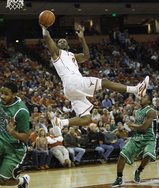 Julien Lewis (áo trắng) của đội bóng rổ bang Texas thực hiện cú lay-up bằng một tay trong trận đấu của giải Hiệp hội các trường đại học quốc gia (NCAA)