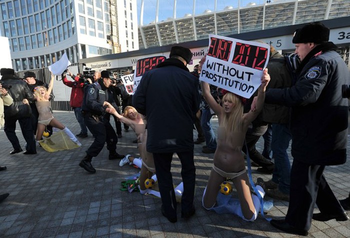 Cảnh sát Ukraine bắt giữ các nhà hoạt động nữ quyền của tổ chức FEMEN trong lúc họ giương cao biểu ngữ "EURO 2012 nói không với nạn mại dâm" trước cửa SVĐ Olympic ở Kiev, vài giờ trước lễ bốc thăm chia bảng giải vô địch châu Âu.
