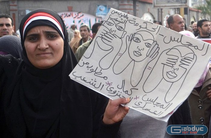 Một người phụ nữ giơ tấm hình tả nghị viện Ai Cập “bịt mắt, bịt tai, che miệng” trước bi kịch tại sân Port Said, với dòng chữ phía dưới ghi: “Nếu chúng im lặng, chúng ta cũng không cần phải nói gì cả”.