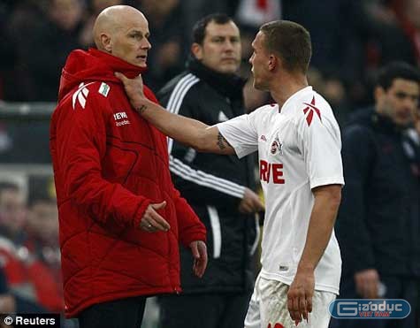 Podolski nắm cổ HLV sau khi bị thẻ đỏ. Ảnh: Reuters