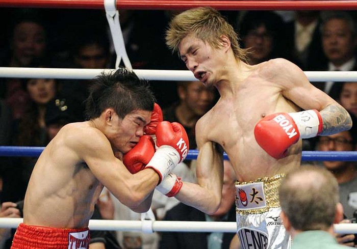 Yota Sato (phải) của Nhật Bản tung một cú đấm móc vào mặt của Suriyan Sor Rungvisai (Thái Lan) trong trận tranh đai hạng siêu ruồi WBC tại Tokyo