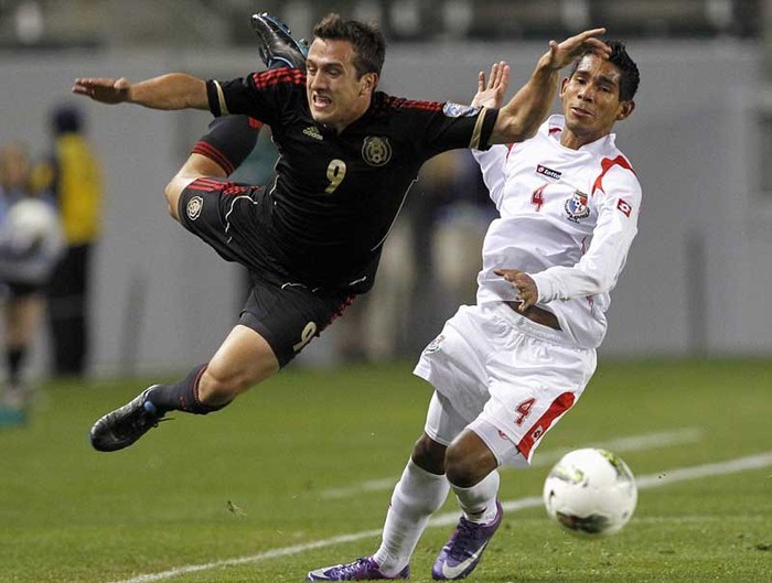 Jeronimo Amione (áo đen) của Mexico ngã trong lúc tranh chấp với Carlos Rodriguez của Panama trong trận đấu ở vòng loại Olympic khu vực CONCACAF