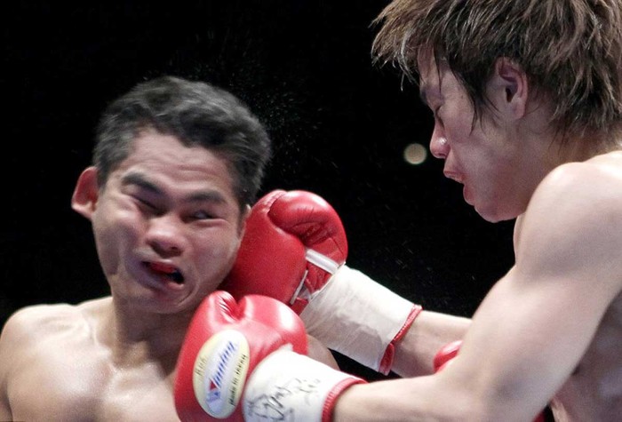 Tomonobu Shimizu tung một cú đấm tay phải vào mặt Tepparith Singwancha trong trận tranh đai vô địch WBA hạng siêu ruồi
