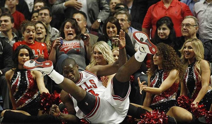 Ronnie Brewer của Chicago Bulls ngã về phía các nữ cổ động viên trong lúc cứu bóng tại một trận đấu với Miami Heat ở giải NBA.