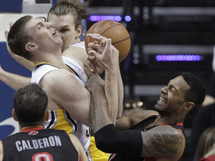 Tyler Hansbrough của Indiana Pacers (áo trắng) và James Johnson của Toronta Raptors (phải) cùng nhảy lên thực hiện cú rebound trong một trận đấu tại NBA.