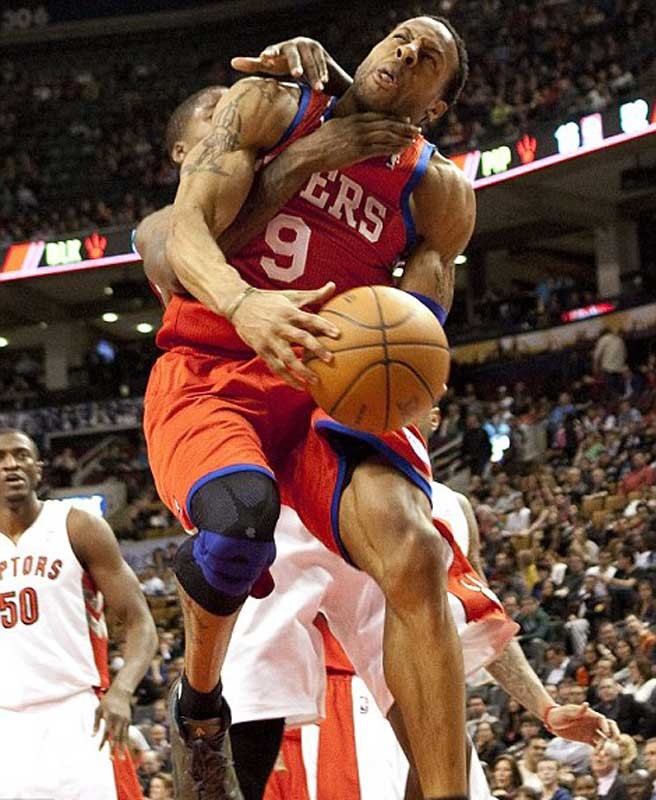 Andre Iguodala (cầm bóng) của Philadelphia 76ers bị Ed Davis của Toronta Raptors phạm lỗi từ phía sau.
