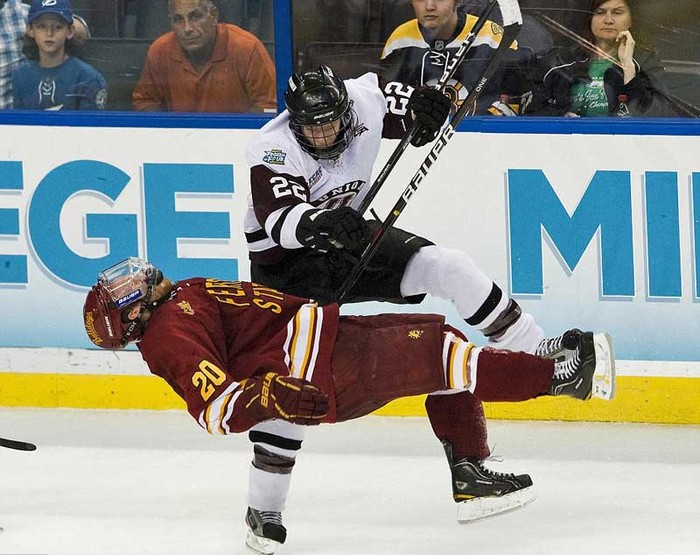 Mat Bodie (số 22) của đội Liên đoàn Đại học đánh ngã Matthew Kirzinger của đội Ferrie State bằng cùi chỏ trong hiệp 3 của trận bán kết giải hockey trên băng các trường Đại học Toàn Mỹ NCAA ở Tampa, Florida.