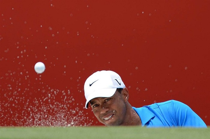 Tiger Woods thực hiện một cú đánh từ hố cát ở vòng 1 giải CIMB Classic ở Kuala Lumpur, Malaysia.