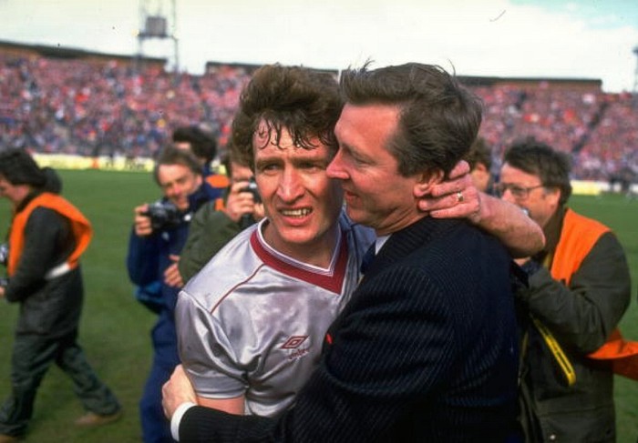 Alex Ferguson ôm lấy Sandy Jardine (trái) của Hearts để an ủi sau khi Aberdeen đánh bại Hearts 3-0 trong trận chung kết cúp QG Scotland, tháng 5/1986. Đó là danh hiệu cuối cùng của Ferguson với Aberdeen.