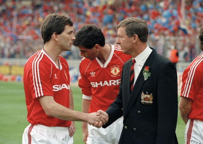 Alex Ferguson bắt tay với thủ quân Bryan Robson trước trận chung kết FA Cup trước Crystal Palace ngày 17/5/1990. FA Cup là cơ hội cuối cùng cho Ferguson và Man Utd để có được danh hiệu năm đó, dù đã bỏ ra rất nhiều tiền để mua về ngôi sao.