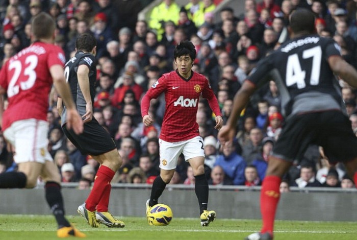 Shinji Kagawa trong vòng vây của các cầu thủ Liverpool.