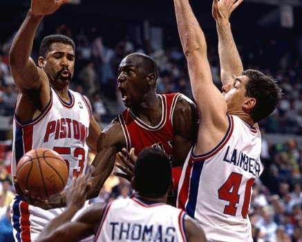 Jordan Rules: Nếu Michael Jordan (áo đỏ) đột phá vào gần bảng rổ, các cầu thủ Detroit Pistons sẽ lập tức chắn trước rổ để chặn Jordan ghi điểm