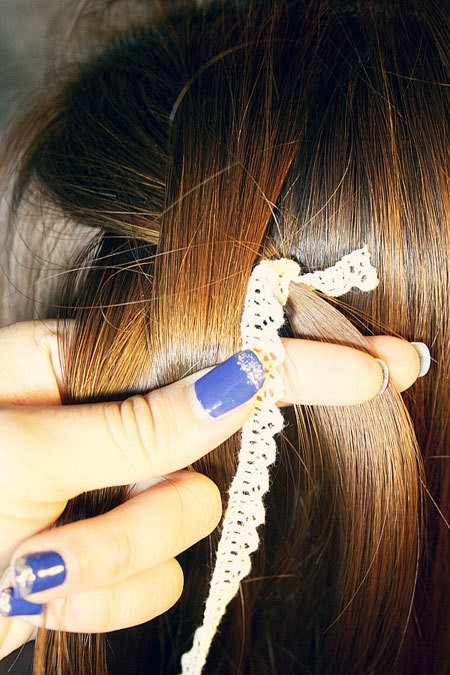 Lấy ba phần tóc ở bên trái, dùng một sợi dây trắng nhỏ cột vào một phần tóc rồi tiến hành tết như bình thường.