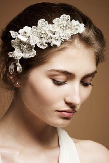 Chỉ cần vén gọn tóc sau đầu và cài thêm một nhành hoa bên trán sẽ giúp khuôn mặt cô dâu đẹp hơn và nữ tính hơn rất nhiều.