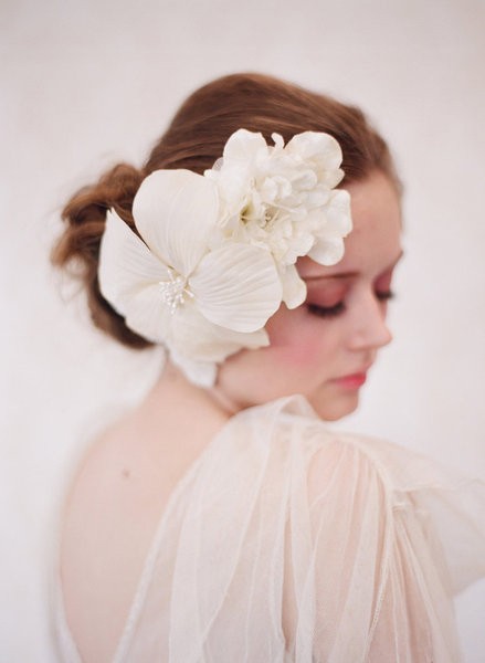 Sử dụng bông hoa trắng to cài một bên mang tai mang lại phong cách cổ điện sang trọng.