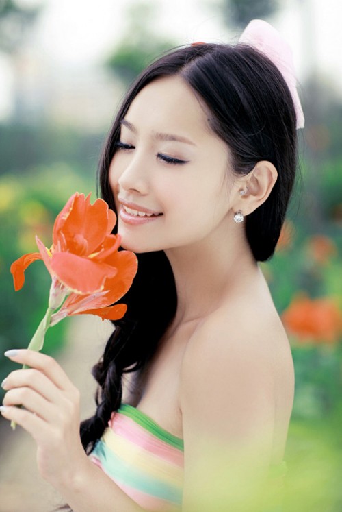 Màu son cam đỏ tạo "đường link" với sắc hoa tươi thắm mang lại cảm giác rạng rỡ tuyệt vời cho cô dâu.