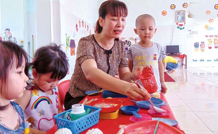 Mặc dù làm công tác quản lý song hàng ngày cô giáo Oanh vẫn thường xuyên gần gũi, tận tình chăm sóc trẻ. (Ảnh: Lã Tiến)