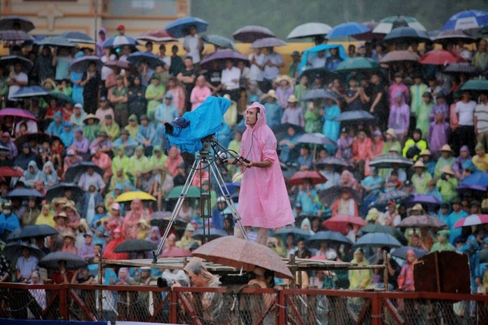 Người dân mặc áo mưa, che ô xem các ông trâu tranh tài (Ảnh: Phong Pink)