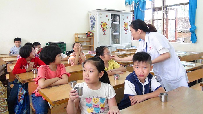 Cán bộ Y tế cho trẻ uống thuốc tẩy giun tại Trường Tiểu học Trần Hưng Đạo (thành phố Hạ Long, Quảng Ninh) - (Ảnh: Minh Khương)